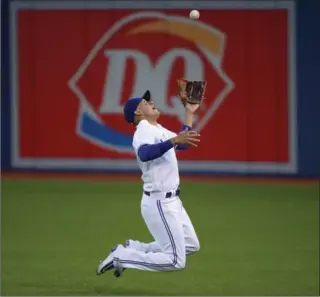  ?? TOM SZCZERBOWS­KI, GETTY IMAGES ?? Blue Jays’ Ryan Goins makes a sliding catch in the fourth inning against the Oakland Athletics at Rogers Centre on Monday night. Goins was also 2-for-4 at the plate with an RBI in Toronto’s 4-2 victory.