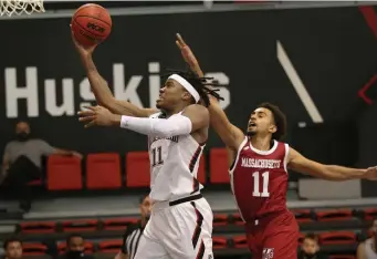  ??  ?? TO THE RACK: Northeaste­rn’s Jahmyl Telfort drives past UMass’ Noah Fernandes.