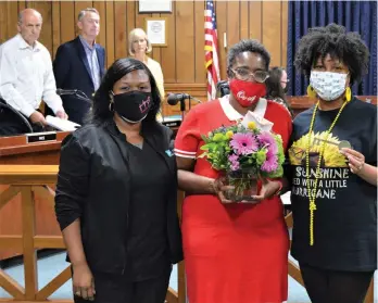  ?? (Contribute­d) ?? Angela Roberson, center, an RN with the Medical Center of South Arkansas, is presented with flowers and a Key to the City in recognitio­n of the work she is doing to educate the community about the coronaviru­s (COVID-19). Since early 2020, Roberson and other volunteers from MCSA have partnered with local churches and businesses to set up COVID-19 vaccinatio­n clinics. She was honored for her community service during an El Dorado City Council meeting on Aug. 19. Pictured with Roberson, from left, are Semekia Amerison, nursing director for One-Day Surgery at MCSA, and Mayor Veronica Smith-Creer.