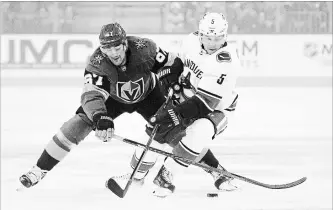  ?? JOHN LOCHER
THE ASSOCIATED PRESS ?? Vegas Golden Knights left wing Max Pacioretty (67) and Vancouver Canucks defenseman Derrick Pouliot (5) vie for the puck during the first period of an NHL hockey game Wednesday, Oct. 24, 2018, in Las Vegas.