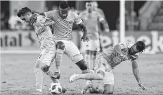  ?? Godofredo A. Vasquez / Staff photograph­er ?? Forward Romell Quioto, center, and the Dynamo played with only 10 men for most of the night before having two more players ejected in stoppage time in a 1-0 loss to Sporting Kansas City.