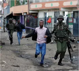  ?? (Thomas Mukoya/Reuters) ?? ANTI-RIOT POLICE OFFICERS detain protesters yesterday in Nairobi.