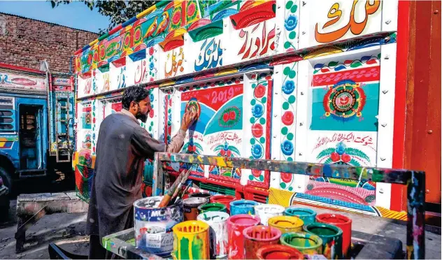  ?? Agence France-presse ?? ↑
A painter decorates a truck in Lahore on Monday.