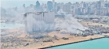  ?? — AFP file photo ?? An aerial view shows the massive damage done to Beirut port’s grain silos (centre) and the area around it, one day after a mega-blast tore through the harbour in the heart of the Lebanese capital with the force of an earthquake, killing more than 100 people and injuring over 4,000.