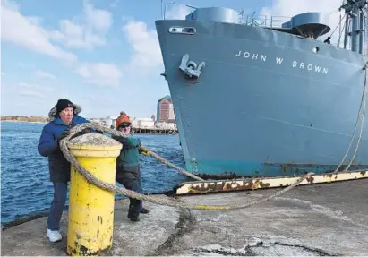  ?? JERRY JACKSON/BALTIMORE SUN PHOTOS ?? Crew members Brian Hope, left, and Ed Koronowski release the forward line as the Liberty ship John W. Brown prepares to move to a new temporary berth at Pier C in Canton. The ship could be forced to relocate again next fall.
