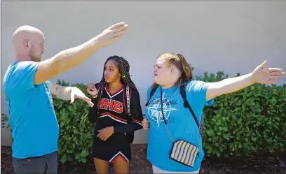  ??  ?? Marysville High freshman Ahloni Smisor, center, gets help finding a classroom from Link Crew co-advisor Ryan Wallace and junior Kaylee Gresham on the first day of school on Wednesday in Marysville. Link Crew is a campus leadership group made up of upperclass­men that help freshmen get acquainted with the school.