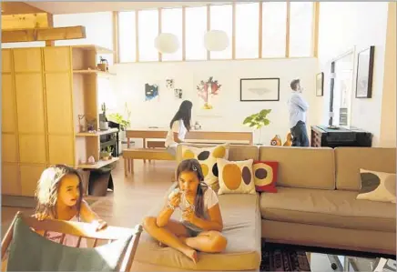  ?? Photograph­s by Genaro Molina Los Angeles Times ?? LEAH, left, and sister Enna relax in the living room while parents Mai Hirai and Barton Corley are in the new multipurpo­se room.