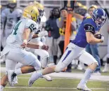  ?? JIM THOMPSON/JOURNAL ?? Manzano’s Andrew Erickson (11) avoids Atrisco Heritage Academy defenders during a game earlier this season. Erickson has had six rushing TDs and nine scoring receptions.