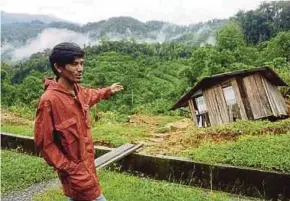  ??  ?? Roddy menunjukka­n keadaan rumahnya selepas kejadian tanah runtuh, di Kiulu, semalam.