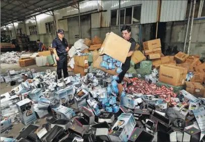  ?? YAO FENG / FOR CHINA DAILY ?? Customs officials destroy a shipment of counterfei­t items that infringed on well-known internatio­nal trademarks in June. The seizure included sunglasses, irons and blenders.