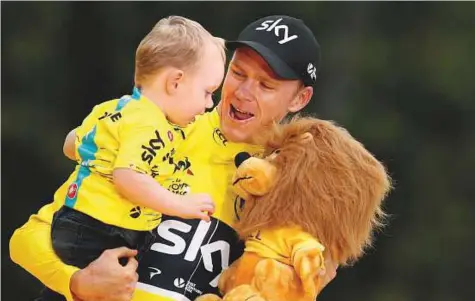  ?? Reuters ?? Team Sky rider and yellow jersey Chris Froome of Britain celebrates his overall win on the podium with his son after the 103km Stage 21 from Montgeron to Paris Champs-Elysees, France in the 104th Tour de France race.