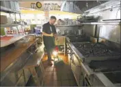  ?? Christophe­r Chung Santa Rosa Press Democrat ?? A PIZZA SHOP worker sweeps by lantern in Santa Rosa, Calif., during PG&E’s early October shut-offs.