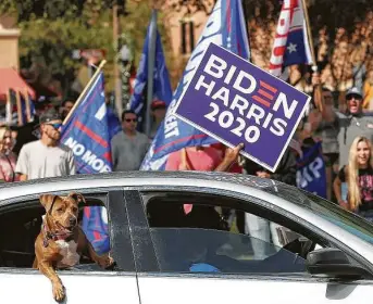  ?? TomReel / Staff photograph­er ?? A motorist gets the attention of Trump supporters by waving a Biden-Harris sign as people fill the town square area in New Braunfels on Nov. 8.