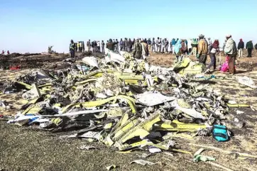  ?? — AFP photo ?? File photo shows people standing near collected debris at the crash site of Ethiopia Airlines which killed 157 people near Bishoftu, a town some 60 kilometres southeast of Addis Ababa.