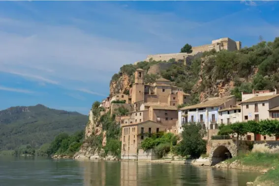  ?? (Shuttersto­ck) ?? The bohemian town of Miravet clings to the water’s edge in the Ebro valley