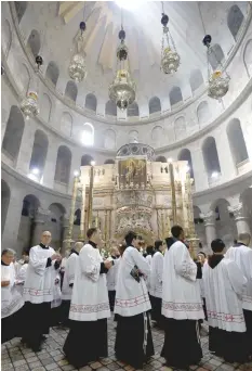  ?? — AFP ?? Clergy pray during the Easter Sunday procession at the Church of the Holy Sepulchre in Jerusalem.