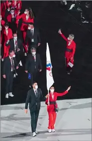  ?? MORRY GASH/AP FILE PHOTO ?? Right, Sofya Velikaya and Maxim Mikhaylov of the Russian Olympic Committee carry the flag during the opening ceremony at the Olympic Stadium at the 2020 Summer Olympics in Tokyo.