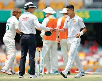  ??  ?? ICC umpire Richard Kettleboro­ugh (left) hands over a cap to Pakistan’s pacer Naseem Shah in this file photo.