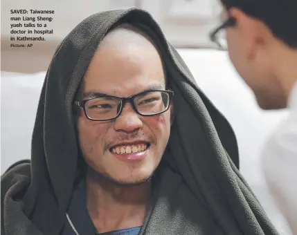  ?? Picture: AP ?? SAVED: Taiwanese man Liang Shengyueh talks to a doctor in hospital in Kathmandu.