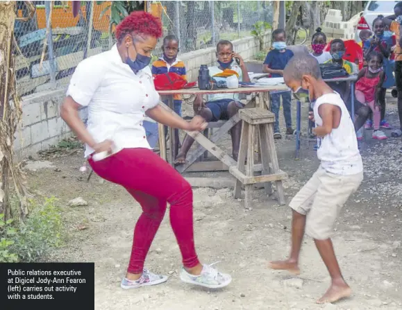  ??  ?? Public relations executive at Digicel Jody-ann Fearon (left) carries out activity with a students.