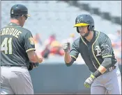  ?? MARK J. TERRILL — ASSOCIATED PRESS ?? Jed Lowrie, right, is congratula­ted by first base coach Al Pedrique after hitting a double for his 1,000th career hit.