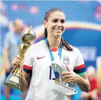  ?? ALEX GRIMM/GETTY ?? Orlando Pride star Alex Morgan celebrates with the FIFA Women’s World Cup Trophy and the Silver Boot Award following the U.S. victory over the Netherland­s in the 2019 Cup final.