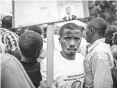  ??  ?? A supporter poses with a placard of presidenti­al candidate Frank Habineza of Rwanda’s Democratic Green Party this week.