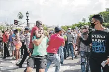  ?? / AFP ?? Un hombre es agarrado por el cuello durante una manifestac­ión contra el gobierno cubano.