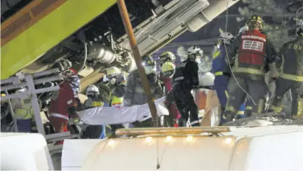  ??  ?? Rescue personnel retrieve bodies from the scene of an accident where subway cars fell after a section of Line 12 of the subway collapsed in Mexico City yesterday