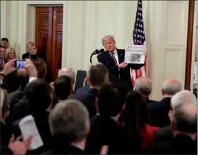  ??  ?? President Donald Trump holds up a copy of The Washington Post with the headline that reads “Trump acquitted” as he speaks in the East Room of the White House in Washington on Thursday.