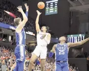  ?? MIKE KROPF AP ?? Virginia's Armaan Franklin (23 points) shoots between Duke's Kyle Filipowski, left, and Mark Mitchell.