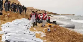  ?? — AP ?? Libyan Red Crescent workers recovering bodies of people that washed ashore, near Zawiya, Libya.