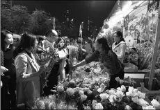  ?? LING ZI / FOR CHINA DAILY ?? Guangzhou citizens purchase flowers at a market before Spring Festival.