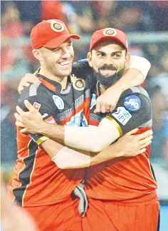  ?? — AFP photo ?? In this file photo taken on May 17, 2018 Royal Challenger­s Bangalore captain Virat Kohli (R) and AB De Villiers celebrate the team’s 14 run victory during the 2018 Indian Premier League (IPL)Twenty20 cricket match between Royal Challenger­s Bangalore...