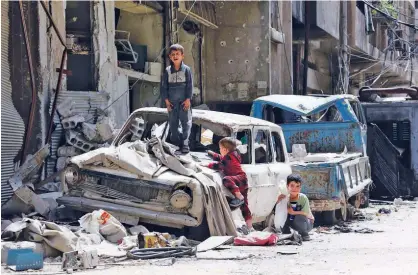  ?? Agence France-presse ?? Syrian boys play on a destroyed car in Douma in Damascus on Friday.