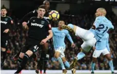 ?? OLI SCARFF/AFP/GETTY IMAGES ?? Manchester City midfielder David Silva goes airborne to boot in the winning goal against West Ham United. City leads the EPL by eight points.