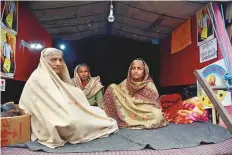  ?? ANI ?? Women farmers brave the cold as they sit inside a tractortro­lley amid their ongoing protest against new farm laws at SInghu border in New Delhi.