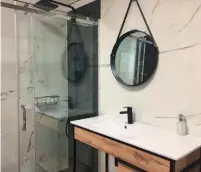  ?? © Photo Mémento ?? La salle de bains graphique, tendance de l’année 2020, utilise des lignes noires pour structurer un espace de couleur neutre. La touche de chaleur et d’exotisme est apportée par les meubles en bois.