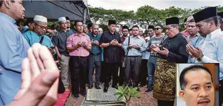  ?? PIC BY MUHAMMAD SULAIMAN ?? Defence Minister Mohamad Sabu (second from right) and visitors praying at the grave of Mat Shuhaimi Shafiei (inset) in Tanah Perkuburan lslam Seksyen 21 in Shah Alam yesterday. Present is Port Klang assemblyma­n Azmizam Zaman Huri (right).