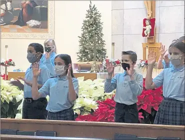  ?? PHOTOS COURTESY OF ST. MARY CATHOLIC SCHOOL ?? Above: St. Mary Catholic School fifth-graders perform “Silent Night” with sign language. At left: St. Mary Catholic School Celebrates the Opening School Mass outdoors.