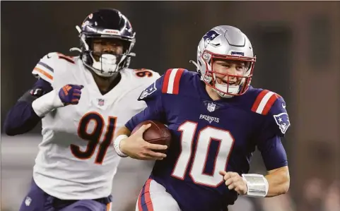  ?? Stew Milne / Associated Press ?? New England Patriots quarterbac­k Mac Jones runs with the ball during the first half against the Chicago Bears Monday in Foxborough, Mass.