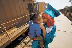  ?? PHOTOS BY LUIS SÁNCHEZ SATURNO/THE NEW MEXICAN ?? Stephanie Solis Mendoza kisses 2-year-old Aiden after picking up her cap and gown Thursday at Capital High.