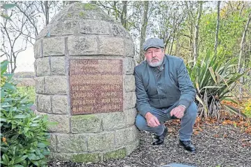 ??  ?? REPAIR JOB: Donald McArthur beside the memorial cairn. Picture by Steve Brown.