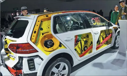  ?? ZHANG TAO / FOR CHINA DAILY ?? Visitors examine a new energy vehicle at an auto show in Zhengzhou. China started offering subsidies in 2009 to stimulate the production and sales of new energy vehicles, a classifica­tion which covers electric cars, plug-in hybrids and fuel-cell cars.