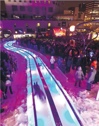  ?? G A Z E T T E / F I L E S ?? Revellers speed down illuminate­d slides at the annual Nuit Blanche, during the Montréal en lumière festival. The festival includes light installati­ons in Old Montreal, the Place des Festivals and other sites.