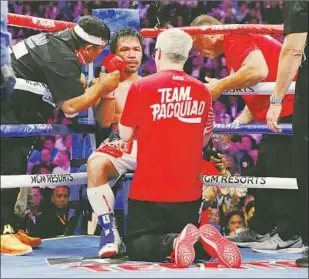  ?? John Locher Associated Press ?? MANNY PACQUIAO began Saturday’s fight looking like a 25-year-old and ended it looking like he was 50. Trainer Freddie Roach, front, said he saw hints that Pacquiao should be done.