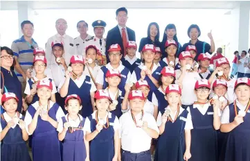  ??  ?? Lau (back row, fourth right) and Chua on his right join other MRC Sibu District officers in a group photo with pupils from one of the winning primary school teams taking part in the parade.