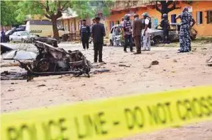  ?? Reuters ?? Policemen stand near damaged vehicles in Sabon Gari, Kano. In recent months there has been a resurgence of clashes between farmers and nomadic herders.