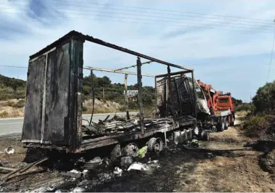 ??  ?? The burned truck is pictured in Sarakina, near Kavala, northern Greece yesterday. Eleven people died after a car thought to be carrying migrants crashed head-on with a truck and burst into flames, police said.