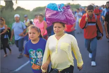  ?? Photograph­s by Pedro Pardo AFP/Getty Images ?? CENTRAL AMERICAN migrants walk from Ciudad Hidalgo, a town on the Mexico-Guatemala border, to the city of Tapachula, more than 20 miles away. The group has grown to about 7,000, nearly all from Honduras.